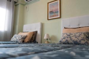 蒙得维的亚Coliving Med by Hotel Mediterràneo的一间卧室配有两张带枕头的床
