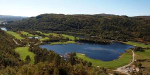 HaugenEnvironmental friendly Ecolodge的享有高尔夫球场和湖泊的空中景致