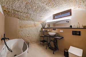 代姆延La Cantina的浴室配有白色浴缸、盥洗盆和浴缸。