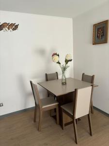 阿里卡Acogedor departamento arica的餐桌和椅子,花瓶