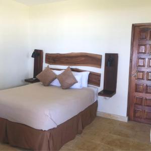 ConchaguaCasa del Golfo El Salvador的一间卧室配有一张带木制床头板和门的床。