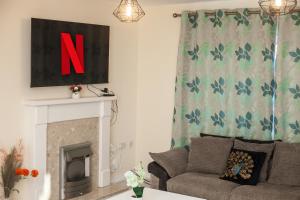 纽尼顿Avril Warwickshire Home Stay的带沙发和壁炉的客厅