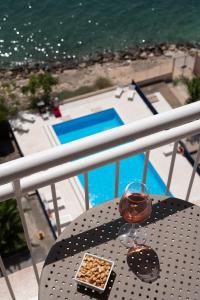 塔兰托Hotel Delfino Taranto的阳台上的桌子上放着一杯葡萄酒和小吃