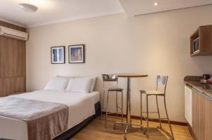 阿雷格里港阿雷格里港千禧蓝树酒店的卧室配有一张床和一张桌子及椅子
