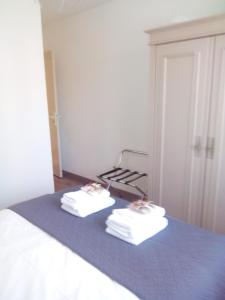 康博莱班BOKATEA的两条毛巾坐在房间里的床边