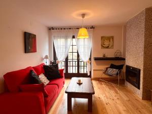 利亚沃尔西Apartament de La Coma的客厅配有红色沙发和茶几