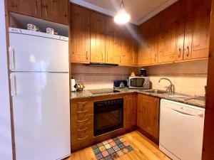 利亚沃尔西Apartament de La Coma的厨房配有白色冰箱和木制橱柜。