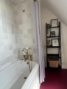 福克斯通The Turret- the best view in Folkestone的带浴缸和淋浴帘的浴室