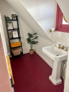 福克斯通The Turret- the best view in Folkestone的一间带水槽和红色地板的浴室