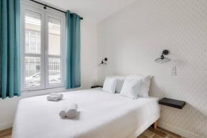 奥贝维利埃Très bel appartement pour 4 aux portes de Paris的一间卧室设有两张白色的床和窗户
