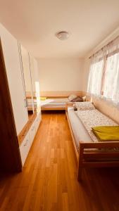 布列瑟农Appartement Nadia的一间卧室设有两张床,铺有木地板