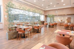 亚松森Paseo La Galería Hotel & Suites的餐厅铺有木地板,配有桌椅