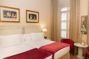 塞维利亚罗马尼亚精品酒店 的卧室配有白色的床和红色毯子