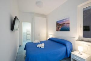 伊斯基亚B&B La Vigna Rooms - Ischia Ponte的一间卧室配有蓝色的床和2条白色毛巾