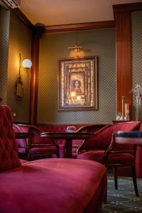 罗马梅斯纳特宫酒店的一间设有红色椅子和墙上一幅画的等候室