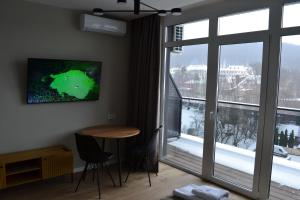 波利亚纳Village apartments Polyana的客房设有桌椅和大窗户。