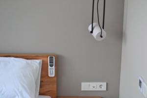 波利亚纳Village apartments Polyana的卧室配有一张位于墙上的遥控器的床