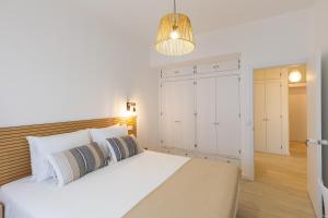 法鲁Faro Guest Apartments的卧室配有白色大床和灯