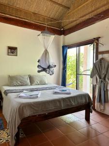 高龙撒冷岛柬埔寨海滨之家旅馆的一间带床的卧室,位于带窗户的房间内