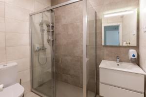 法鲁Faro Guest Apartments的带淋浴、卫生间和盥洗盆的浴室