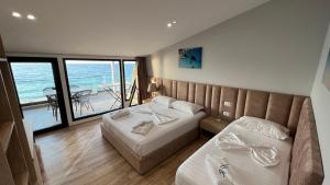 伏罗拉Hotel Tramonto Vlore的一间带两张床的卧室,享有海景