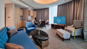 多哈Millennium Place Doha的客厅配有蓝色的沙发和电视