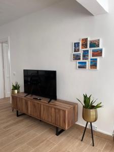 卡门港Bungalow Ara的客厅配有木桌上的平面电视