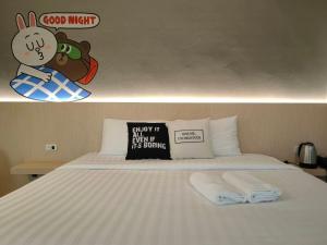 SadaoParamount Palace Hotel Dannok的一间卧室配有一张床,上面有两条毛巾