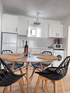 卡门港Bungalow Ara的厨房配有桌椅和一瓶葡萄酒