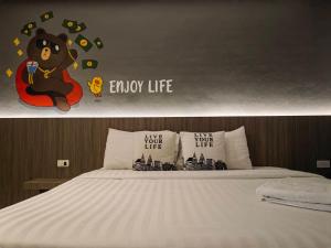 SadaoParamount Palace Hotel Dannok的卧室配有一张床铺,墙上挂着泰迪熊