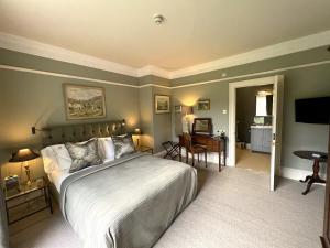 马沙姆史云顿公园酒店的一间卧室配有一张床,另一间卧室配有书桌