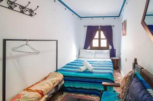 舍夫沙万Dar Chourafa Riad的一间小卧室,配有一张带窗户的床