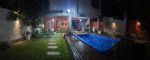 GualeguaychúFabiana的夜间在房子的院子中的一个游泳池