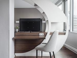 汉堡numa I Fore Rooms & Apartments的客厅配有电视和椅子