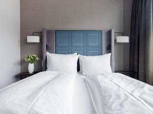汉堡numa I Fore Rooms & Apartments的一张白色的大床,配有白色枕头和蓝色门