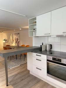 布雷根茨Stylische Wohnung im Herzen von Bregenz mit privatem Parkplatz的厨房配有白色橱柜和餐桌