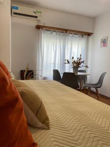 布宜诺斯艾利斯Apartamento Carlota的一间卧室配有一张大床和一张桌椅