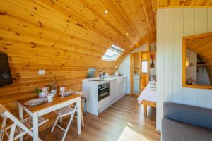 GalstonThe Stag Pod Farm Stay with Hot Tub Sleeps 2 Ayrshire Rural Retreats的厨房和带木制天花板的客厅