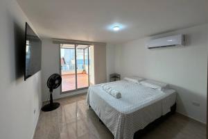 哥伦比亚港Apartamento Victoria的白色的卧室设有床和窗户