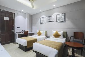 新德里Cosy Grand, Near Chanakyapuri, Embassy Area的酒店客房配有两张床和一张书桌