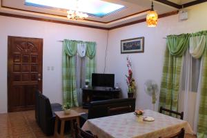 莫阿尔博阿Kojie Guest House的一间带桌子和电视的用餐室