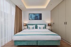 蒂瓦特Hotel Splendido Bay的一间卧室配有一张大床和蓝色床头板