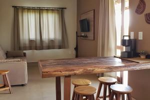 戈亚斯州上帕莱索Canto do Paraíso - Aluguel para Temporada的客厅配有一张大木桌和凳子