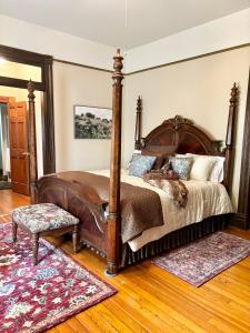 开普吉拉多MacFie House的卧室配有一张大型木床和地毯。