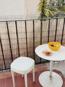 马赛Marina Motel的一张白色的桌子、一把椅子和一碗水果