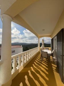 楼尔Casa Amar的设有一个配有桌椅并享有美景的阳台。