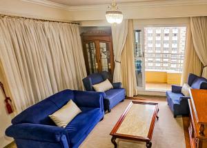 坎皮纳斯Hotel Euro Suite Campinas的客厅配有蓝色的沙发和桌子