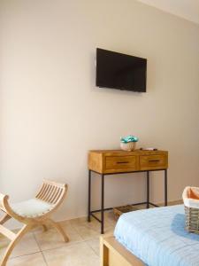 AyiáStelia Apartment的一间房间,墙上有椅子和电视