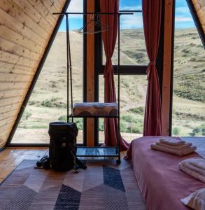 DrakhtikFocus Point Drakhtik - Rose Cabin的窗户前设有一张床和一把椅子的房间