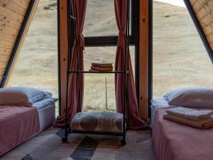 DrakhtikFocus Point Drakhtik - Rose Cabin的客房设有两张床,窗户前设有一张桌子
